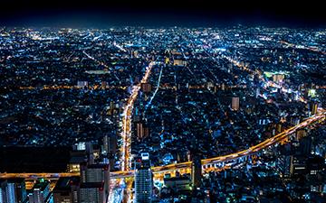 Aerial view of a large city at night beaming with city lights