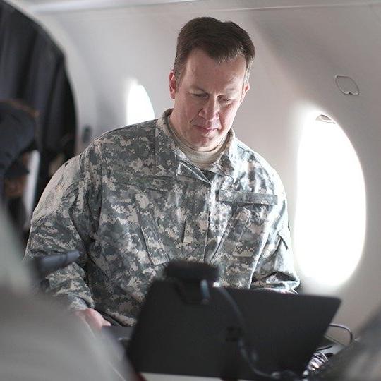 Warfighter connected to his laptop while flying on a 政府飞机 equipped with dual-band antennas