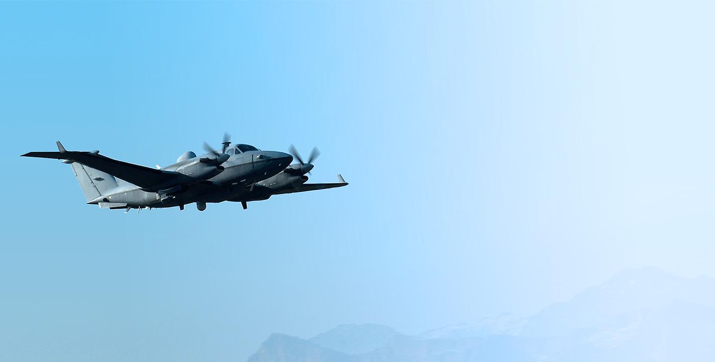 MC-12 空气craft flying against a light blue sky