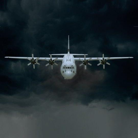 一架C-130J飞机在乌云中飞行的前视图