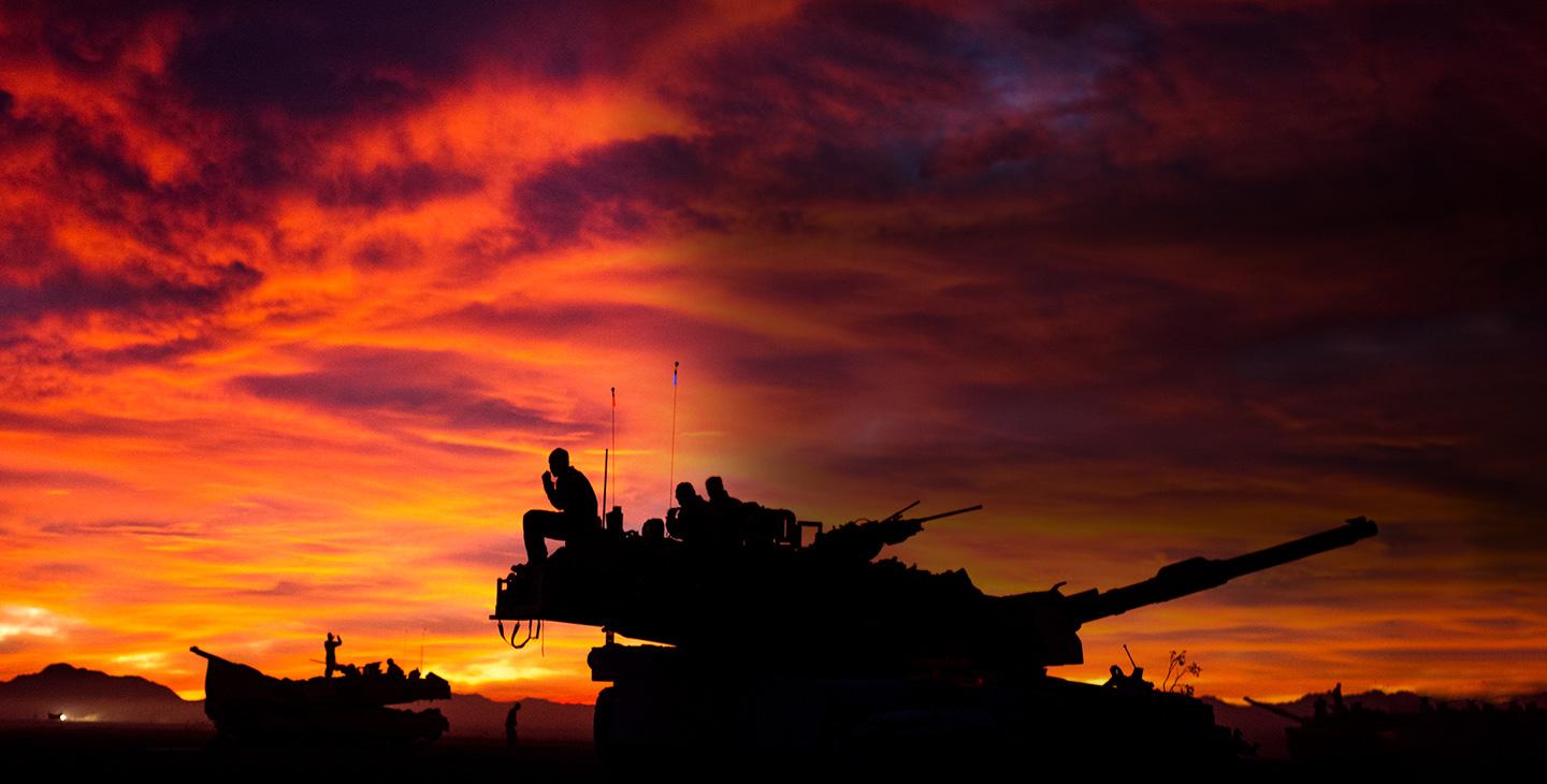 Silhouette of two tanks and soldiers